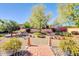 Beautifully landscaped backyard with a brick pathway, mature trees, and decorative gravel at 5421 E Michelle Dr, Scottsdale, AZ 85254