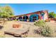 Back exterior view of house with covered patio and landscaped backyard with desert rock and potted plants at 5421 E Michelle Dr, Scottsdale, AZ 85254