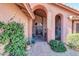 Inviting arched entryway with wrought iron gates, brick walkway, and verdant landscaping elements at 5421 E Michelle Dr, Scottsdale, AZ 85254