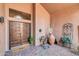 Charming front porch features a wood door, decorative plants, and a cozy welcome mat at 5421 E Michelle Dr, Scottsdale, AZ 85254