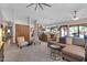 Open-concept living room with neutral tones, ceiling fan, and adjacent kitchen area at 5421 E Michelle Dr, Scottsdale, AZ 85254