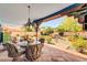 Outdoor dining area on a tiled patio with a view of a beautifully landscaped backyard at 5421 E Michelle Dr, Scottsdale, AZ 85254