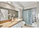 Light bathroom features a granite countertop, a large mirror, and a shower with floral curtain at 6310 E Avalon Dr, Scottsdale, AZ 85251