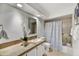 Bright bathroom features a granite countertop, white cabinets, and a shower with a patterned curtain at 6310 E Avalon Dr, Scottsdale, AZ 85251