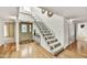 Bright foyer with wood floors features a staircase with white railings and a decorative front door at 6310 E Avalon Dr, Scottsdale, AZ 85251