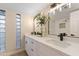 Modern bathroom showcasing double sinks, quartz counters, glass block windows, and stylish light fixtures at 6802 N 22Nd Pl, Phoenix, AZ 85016