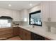 Modern kitchen design showcasing white cabinets, sleek countertops, modern appliances, and bright natural light from a large window at 6802 N 22Nd Pl, Phoenix, AZ 85016