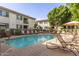 Relaxing community pool surrounded by lounge chairs, umbrellas, and manicured landscaping at 6900 E Princess Dr # 1228, Phoenix, AZ 85054