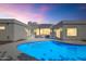 Backyard with a large pool, lighting, and a view of the setting sun at 8336 N 72Nd Pl, Scottsdale, AZ 85258