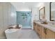 Elegant bathroom with a freestanding tub, glass shower, and a double vanity with modern fixtures at 8336 N 72Nd Pl, Scottsdale, AZ 85258