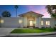 Twilight view of a charming one-story home with a well-manicured lawn and attached two-car garage at 8336 N 72Nd Pl, Scottsdale, AZ 85258