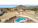 Aerial view featuring a fenced pool, a detached garage/workshop, and a large gravel yard with mountain views at 9120 W Villa Lindo Dr, Peoria, AZ 85383