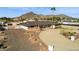 Aerial view of a charming desert home surrounded by a circular driveway, a single palm tree, and mountain views at 9120 W Villa Lindo Dr, Peoria, AZ 85383