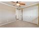 A carpeted bedroom featuring a ceiling fan and access to the bathroom at 9120 W Villa Lindo Dr, Peoria, AZ 85383