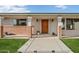 Charming front entrance with brick accents, columns, and a meticulously manicured lawn leading to a wooden front door at 9120 W Villa Lindo Dr, Peoria, AZ 85383