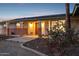 Inviting front porch with a wooden door, desert landscaping, and decorative lighting at 9120 W Villa Lindo Dr, Peoria, AZ 85383