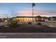 Inviting home exterior at dusk with illuminated circular driveway and manicured landscaping, showcasing desert charm at 9120 W Villa Lindo Dr, Peoria, AZ 85383