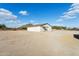 Exterior view of the outbuilding on the property, featuring a roll-up door and surrounded by an open desert landscape at 9120 W Villa Lindo Dr, Peoria, AZ 85383