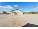 Outbuilding exterior with a garage door on a dirt lot at 9120 W Villa Lindo Dr, Peoria, AZ 85383