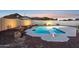 Sparkling pool featuring a diving board and beautiful rock landscaping against a backdrop of mountains at sunset at 9120 W Villa Lindo Dr, Peoria, AZ 85383