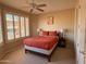 Bright bedroom with a ceiling fan, plantation shutters, and a comfortable bed with a wooden frame at 10222 E Southwind Ln # 1054, Scottsdale, AZ 85262