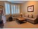 Bright living room with bay window, plantation shutters, a cozy sofa, loveseat, and decorative coffee table at 10222 E Southwind Ln # 1054, Scottsdale, AZ 85262