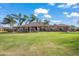 Spacious backyard featuring a covered patio, expansive lawn, and mature palm trees for outdoor living at 1096 W Via De Palmas --, San Tan Valley, AZ 85140
