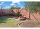 Unique backyard featuring a custom fire pit, brick wall, and lovely landscaping, creating a charming outdoor space at 1096 W Via De Palmas --, San Tan Valley, AZ 85140