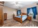 Bedroom with wood floors, a ceiling fan, a four-poster bed, and blue accents at 1096 W Via De Palmas --, San Tan Valley, AZ 85140