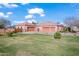 Spacious home featuring a large manicured lawn and multiple garages offering ample parking and storage space at 1096 W Via De Palmas --, San Tan Valley, AZ 85140