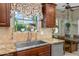 Kitchen sink with granite countertops, wooden cabinets, and a view of the backyard at 1096 W Via De Palmas --, San Tan Valley, AZ 85140
