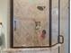 Walk-in shower featuring decorative tiling, recessed shelving, and modern fixtures at 1096 W Via De Palmas --, San Tan Valley, AZ 85140