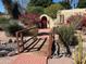 Landscaped front yard featuring a wooden bridge, red brick path, and decorative shrubs at 11018 N 42Nd St, Phoenix, AZ 85028