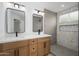 Stylish bathroom with dual sinks, modern mirrors, and a walk-in shower featuring decorative tile at 1120 W Barrow Dr, Chandler, AZ 85224