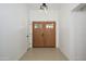 Inviting entryway with wood double doors, neutral tile flooring, and fresh white walls at 1120 W Barrow Dr, Chandler, AZ 85224