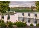 Picturesque view of the golf course and water feature, with a clubhouse and mountains in the distance at 11300 N Casa Dega Dr # 1006, Surprise, AZ 85388