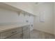 Functional laundry room equipped with modern cabinets, shelving, and tiled floors at 11300 N Casa Dega Dr # 1006, Surprise, AZ 85388