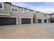 Townhome exterior with multiple garage doors and a patterned brick driveway at 11300 N Casa Dega Dr # 1020, Surprise, AZ 85388