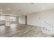 Spacious open living area with wood-look flooring, neutral walls, and staircase leading to a second level at 11300 N Casa Dega Dr # 1020, Surprise, AZ 85388