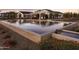 Clubhouse reflecting in a serene pond with cascading water features and lush landscaping at 11300 N Casa Dega Dr # 1020, Surprise, AZ 85388