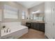Elegant bathroom features a soaking tub, double sink vanity, and large mirror at 12047 E Sereno Rd, Gold Canyon, AZ 85118