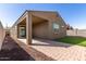 Backyard view of patio and house, featuring rock landscaping and artificial turf at 12324 W Northview Ave, Glendale, AZ 85307