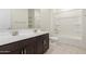 Bright bathroom featuring a double vanity, framed mirror, and shower over tub at 12324 W Northview Ave, Glendale, AZ 85307