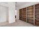 Bedroom with light carpet, a view of the bathroom, and wooden bookcase-style built-ins at 12324 W Northview Ave, Glendale, AZ 85307