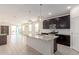 Bright kitchen with dark cabinets, granite counters, stainless appliances, and opens to the living room at 12324 W Northview Ave, Glendale, AZ 85307