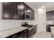 Modern kitchen featuring sleek dark cabinets, stainless steel appliances, and granite countertops at 12324 W Northview Ave, Glendale, AZ 85307