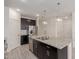 Modern kitchen features dark cabinetry, stainless steel appliances, granite countertops, tile backsplash and island sink at 12324 W Northview Ave, Glendale, AZ 85307