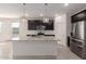 Modern kitchen boasts dark cabinetry, stainless steel appliances, granite countertops, and tile flooring at 12324 W Northview Ave, Glendale, AZ 85307