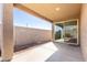 View of covered patio and backyard with rock landscaping, a block fence, and sliding glass doors at 12324 W Northview Ave, Glendale, AZ 85307