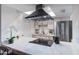Bright kitchen features a modern cooktop island, stainless steel appliances, range hood, and white cabinetry at 1455 N Alma School Rd # 38, Mesa, AZ 85201
